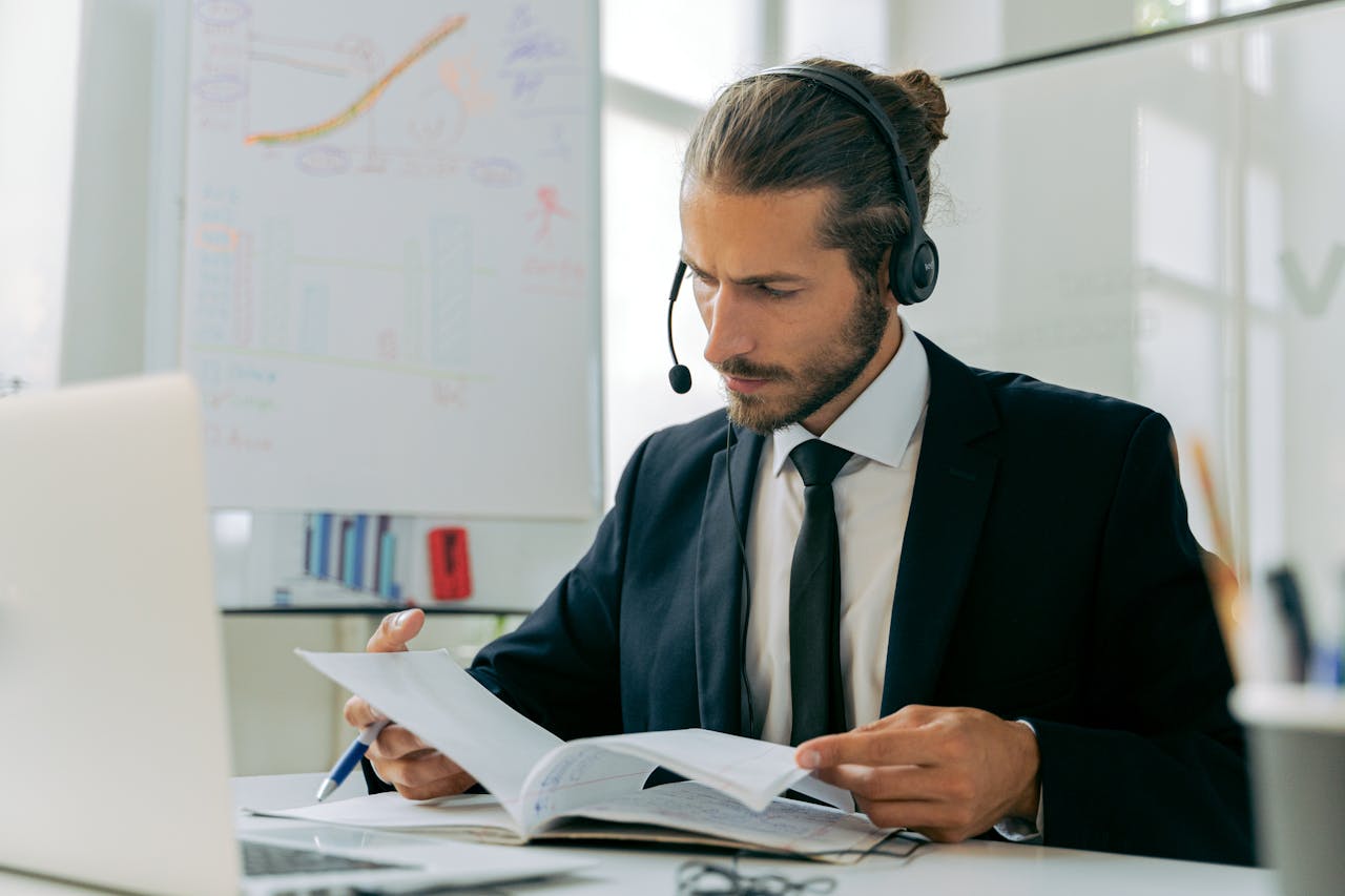 Focused business professional handling customer service tasks with a headset in an office setting.